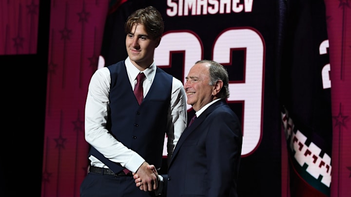 Jun 28, 2023; Nashville, Tennessee, USA; Arizona Coyotes draft pick Dmitriy Simashev shakes hands with NHL commissioner Gary Bettman after being selected with the sixth pick in round one of the 2023 NHL Draft at Bridgestone Arena. Mandatory Credit: Christopher Hanewinckel-Imagn Images