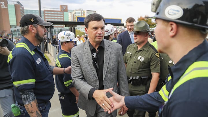 Oct 12, 2024; Morgantown, West Virginia, USA; West Virginia Mountaineers head coach Neal Brown shakes the hands of coal miners who led the team into the stadium before their game against the Iowa State Cyclones at Mountaineer Field at Milan Puskar Stadium. Mandatory Credit: Ben Queen-Imagn Images