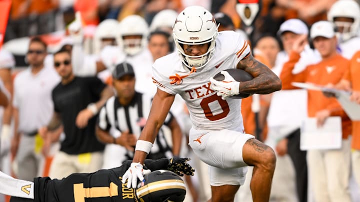 Texas Longhorns wide receiver DeAndre Moore Jr. (0) stiff arms Vanderbilt Commodores safety CJ Taylor (1) as he crosses the goal line during the first half at FirstBank Stadium.