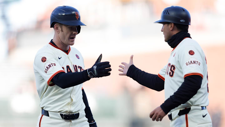 San Francisco Giants first baseman Mark Canha (16) celebrates with first base coach Mark Hallberg (91) after hitting a single during the first inning against the Atlanta Braves at Oracle Park.