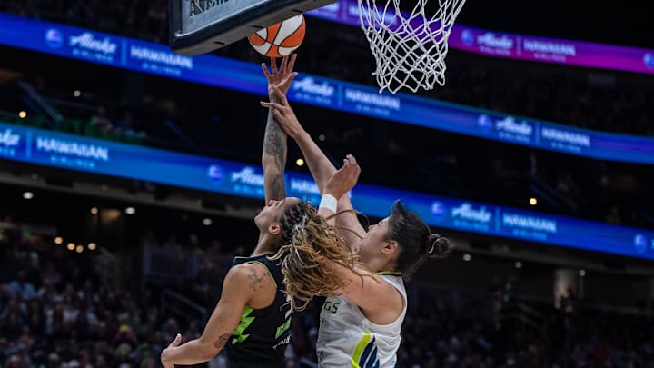 Jul 22, 2025; Seattle, Washington, USA;  Seattle Storm forward Gabby Williams (5) shoots the ball against Dallas Wings center Li Yueru (28) during the first half at Climate Pledge Arena. Mandatory Credit: Stephen Brashear-Imagn Images