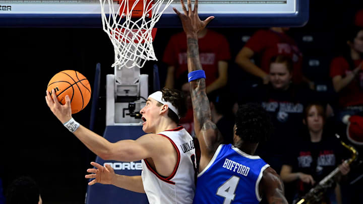 Belmont guard Tyler Lundblade (8) lays the ball up for a basket past MTSU guard Justin Bufford (4) during an NCAA college basketball game Saturday, Dec. 7, 2024, in Nashville, Tenn.