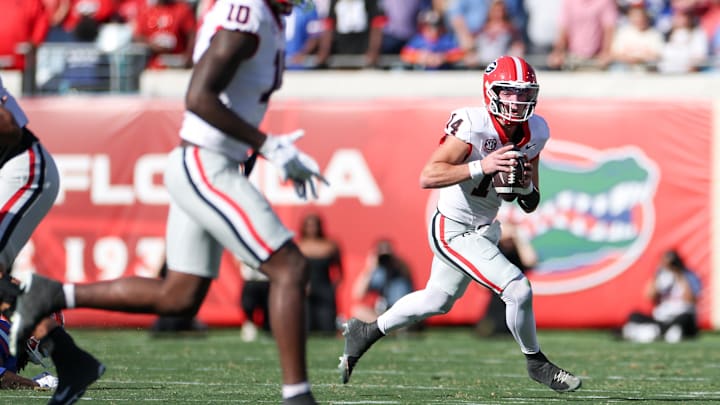 Nov 1, 2025; Jacksonville, Florida, USA; Georgia Bulldogs quarterback Gunner Stockton (14) scrambles out of the pocket in the first quarter against the Florida Gators at EverBank Stadium. Mandatory Credit: Matt Pendleton-Imagn Images