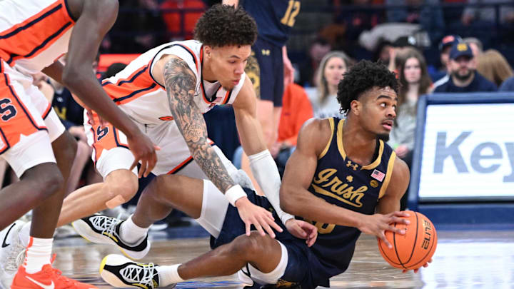 Jan 31, 2026; Syracuse, New York, USA; Notre Dame Fighting Irish forward Jalen Haralson (10) gets control of a loose ball before Syracuse Orange guard Nate Kingz (4) in the second half at the JMA Wireless Dome. Mandatory Credit: Mark Konezny-Imagn Images Jan 31, 2026; Syracuse, New York, USA; Notre Dame Fighting Irish forward Jalen Haralson (10) gets control of a loose ball before Syracuse Orange guard Nate Kingz (4) in the second half at the JMA Wireless Dome. Mandatory Credit: Mark Konezny-Imagn Images