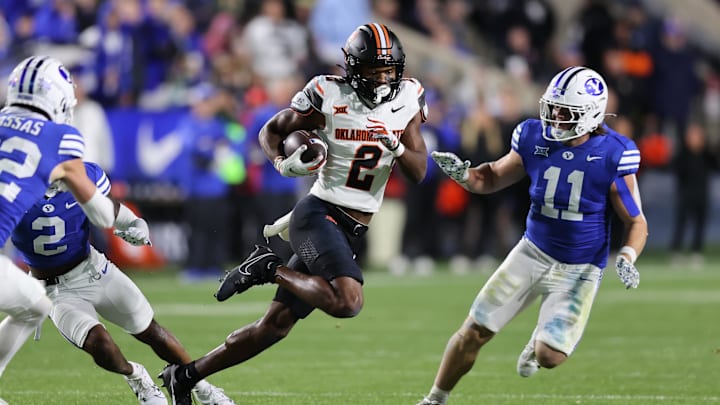Oct 18, 2024; Provo, Utah, USA; Oklahoma State Cowboys wide receiver Talyn Shettron (2) runs the ball defended by Brigham Young Cougars linebacker Harrison Taggart (11) during the third quarter at LaVell Edwards Stadium. Mandatory Credit: Rob Gray-Imagn Images