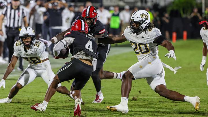 Aug 28, 2025; Orlando, Florida, USA; Jacksonville State Gamecocks running back Cam Cook (4) runs the ball as UCF Knights linebacker Lewis Carter (20) moves in during the second quarter at Acrisure Bounce House. Mandatory Credit: Mike Watters-Imagn Images Aug 28, 2025; Orlando, Florida, USA; Jacksonville State Gamecocks running back Cam Cook (4) runs the ball as UCF Knights linebacker Lewis Carter (20) moves in during the second quarter at Acrisure Bounce House. Mandatory Credit: Mike Watters-Imagn Images