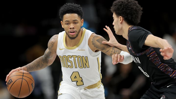 Jan 23, 2026; Brooklyn, New York, USA; Boston Celtics guard Anfernee Simons (4) brings the ball up court against Brooklyn Nets guard Nolan Traore (88) during the first quarter at Barclays Center. Mandatory Credit: Brad Penner-Imagn Images
