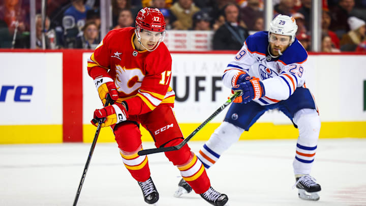 Nov 3, 2024; Calgary, Alberta, CAN; Calgary Flames center Yegor Sharangovich (17) and Edmonton Oilers center Leon Draisaitl (29) battles for the puck during the third period at Scotiabank Saddledome. Mandatory Credit: Sergei Belski-Imagn Images