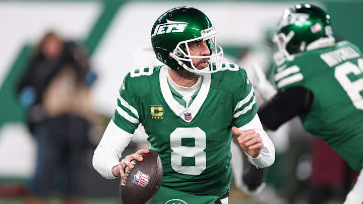 Jan 5, 2025; East Rutherford, New Jersey, USA; New York Jets quarterback Aaron Rodgers (8) rolls out during the first half against the Miami Dolphins at MetLife Stadium. Mandatory Credit: Vincent Carchietta-Imagn Images