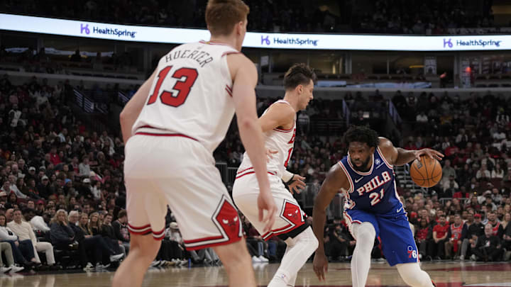 Dec 26, 2025; Chicago, Illinois, USA; Chicago Bulls forward Zach Collins (12) defends Philadelphia 76ers center Joel Embiid (21) during the second half at United Center. Mandatory Credit: David Banks-Imagn Images