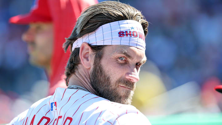 Philadelphia Phillies first base Bryce Harper looks on in the dugout against the Boston Red Sox. Philadelphia Phillies first base Bryce Harper looks on in the dugout against the Boston Red Sox.