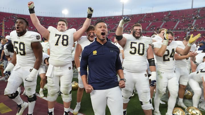 Notre Dame head coach Marcus Freeman and players celebrate after defeating USC.