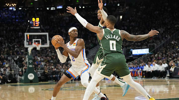 Mar 24, 2024; Milwaukee, Wisconsin, USA;  Oklahoma City Thunder guard Shai Gilgeous-Alexander (2) looks to pass the ball under pressure from Milwaukee Bucks forward Giannis Antetokounmpo (34) and guard Damian Lillard (0) during the first quarter at Fiserv Forum. Mandatory Credit: Jeff Hanisch-Imagn Images