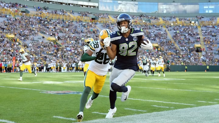 Aug 23, 2025; Green Bay, Wisconsin, USA; Seattle Seahawks wide receiver Cody White (82) is pushed out of bounds by Green Bay Packers cornerback Micah Robinson (26) after catching a pass during the fourth quarter at Lambeau Field. 
