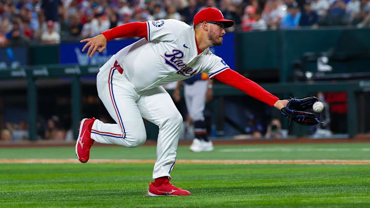 Aug 6, 2024; Arlington, Texas, USA; Texas Rangers starting pitcher Dane Dunning (33) makes a catch during the eighth inning against the Houston Astros at Globe Life Field. 