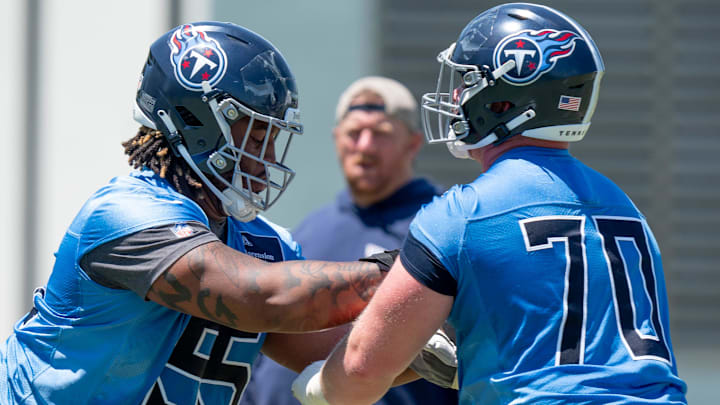 Offensivle lineman JC Latham (55) and Cole Spencer (70) run drills during Tennessee Titans practice at Ascension Saint Thomas Sports Park in Nashville, Tenn., Tuesday, May 21, 2024.
