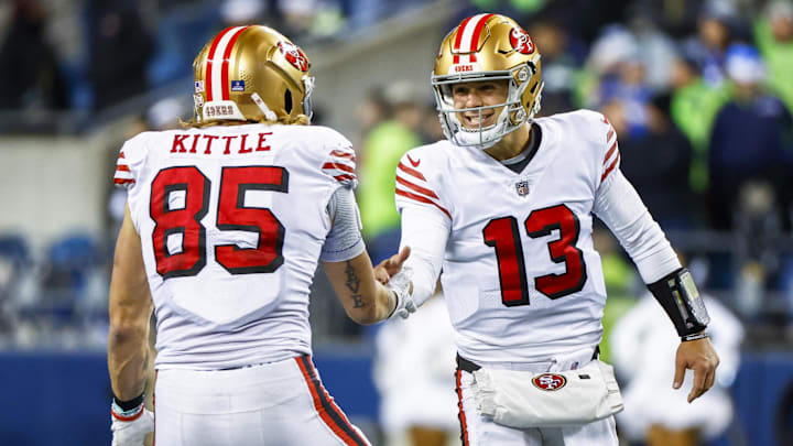 San Francisco 49ers quarterback Brock Purdy (13) celebrates with tight end George Kittle (85) during the late fourth quarter against the Seattle Seahawks at Lumen Field.