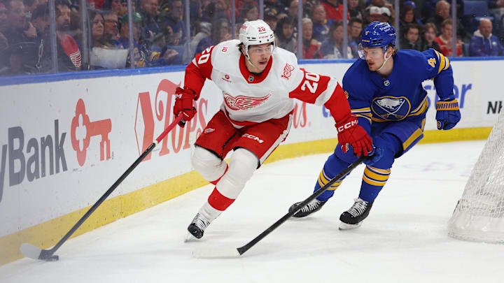 Mar 27, 2026; Buffalo, New York, USA;  Detroit Red Wings defenseman Albert Johansson (20) looks to make a pass as Buffalo Sabres defenseman Bowen Byram (4) defends during the first period at KeyBank Center. Mandatory Credit: Timothy T. Ludwig-Imagn Images