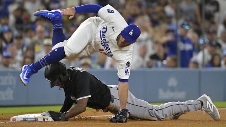 Jul 2, 2025; Los Angeles, California, USA;  Los Angeles Dodgers third baseman Max Muncy (13) is injured as he flips over Chicago White Sox right fielder Michael A. Taylor (21) after tagging him out on an attempted steal in the fifth inning at Dodger Stadium. Mandatory Credit: Jayne Kamin-Oncea-Imagn Images