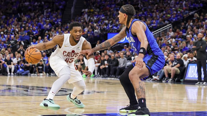 Cleveland Cavaliers guard Donovan Mitchell (45) handles the ball against Orlando Magic forward Paolo Banchero (5) during the second half of game six of the first round for the 2024 NBA playoffs at Kia Center.