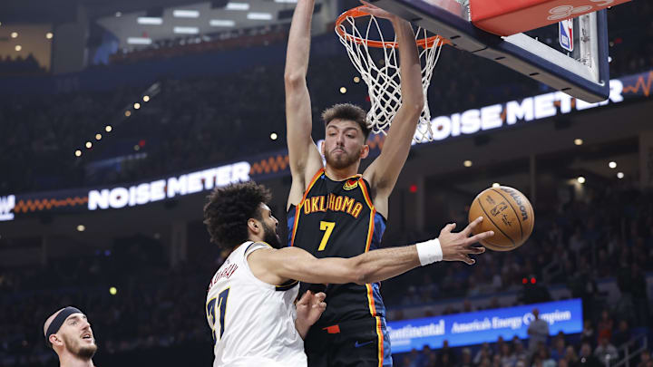 Mar 9, 2025; Oklahoma City, Oklahoma, USA; Denver Nuggets guard Jamal Murray (27) passes around Oklahoma City Thunder forward Chet Holmgren (7) during the second quarter at Paycom Center. Mandatory Credit: Alonzo Adams-Imagn Images
