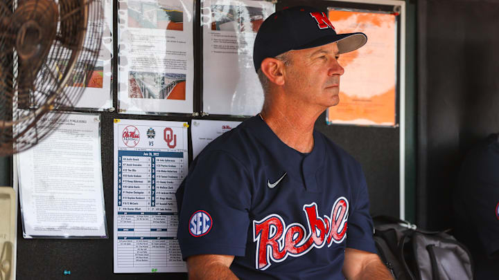 Jun 26, 2022; Omaha, NE, USA; Ole Miss Head Coach Mike Bianco sits in the dugout just before the first inning against the Oklahoma Sooners at Charles Schwab Field. Mandatory Credit: Jaylynn Nash-Imagn Images