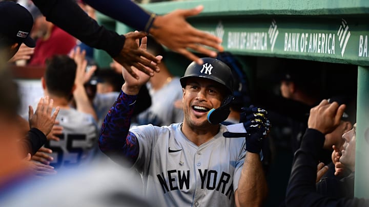 Jun 15, 2024; Boston, Massachusetts, USA;  New York Yankees designated hitter Giancarlo Stanton (27) is greeted in the dugout after scoring a run during the second inning against the Boston Red Sox at Fenway Park. Mandatory Credit: Bob DeChiara-Imagn Images