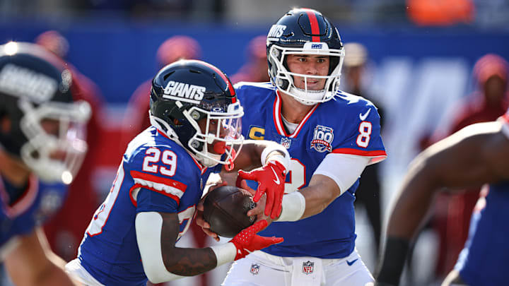 Nov 3, 2024; East Rutherford, New Jersey, USA; New York Giants quarterback Daniel Jones (8) hands off to New York Giants running back Tyrone Tracy Jr. (29) during the first half at MetLife Stadium. Mandatory Credit: Vincent Carchietta-Imagn Images