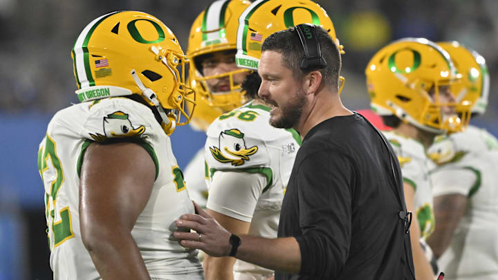 Sep 28, 2024; Pasadena, California, USA; Oregon Ducks head coach Dan Lanning talks to Oregon Ducks offensive lineman Iapani Laloulu (72) during a timeout in the fourth quarter against the UCLA Bruins at Rose Bowl. Mandatory Credit: Robert Hanashiro-Imagn Images