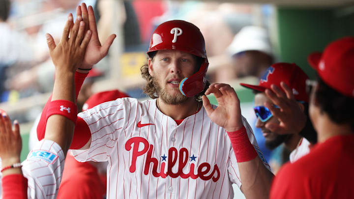 Mar 24, 2025; Clearwater, Florida, USA;  Philadelphia Phillies third base Alec Bohm (28) is congratulated after he scored a run against the Tampa Bay Rays during the first inning at BayCare Ballpark