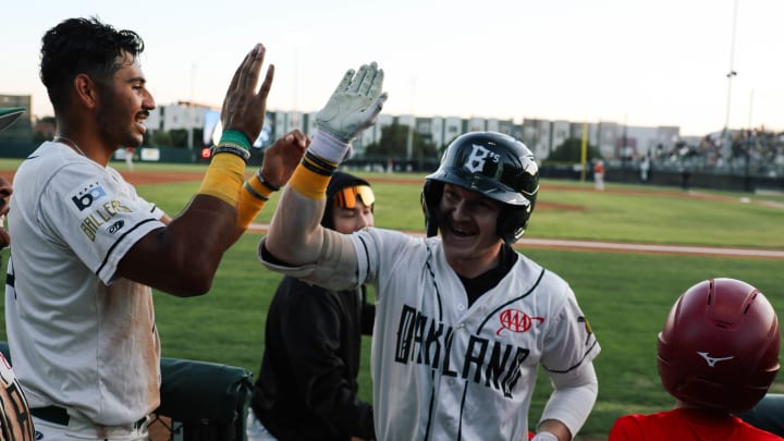 Oakland Ballers teammates high five in celebration Oakland Ballers teammates high five in celebration