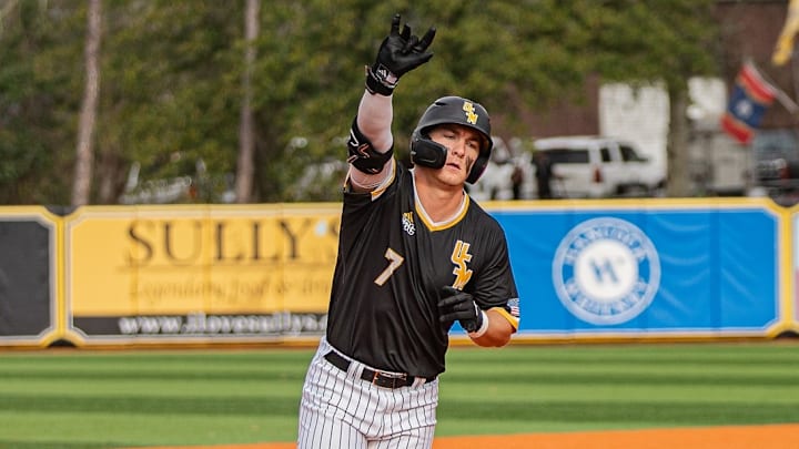 Senior outfielder Ben Higdon celebrates after hitting a solo homer off the "Tradition of Excellence" sign in left field.