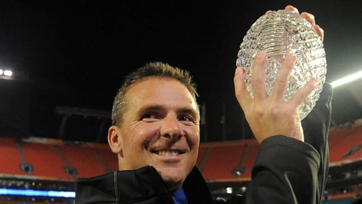 Jan 8, 2009; Miami, FL, USA; Florida Gators head coach Urban Meyer walks off the field holding the championship trophy after defeating the Oklahoma Sooners 24-14 in the 2009 BCS Championship Game at Dolphin Stadium.  Mandatory Credit: James Lang-Imagn Images