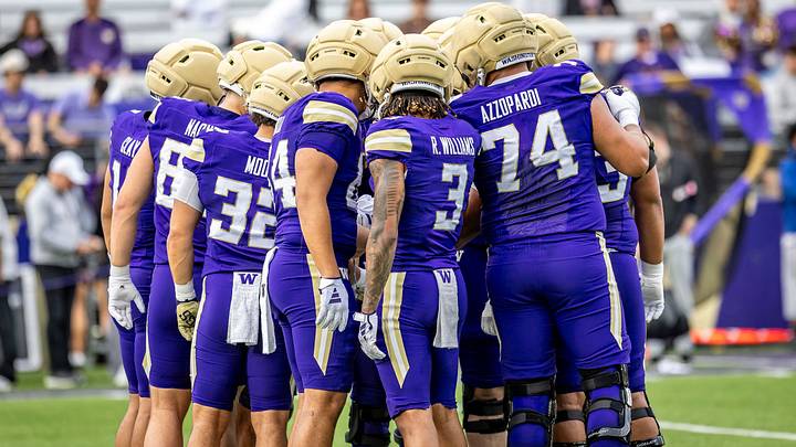 The Husky purple team huddles during the Spring Game. The Husky purple team huddles during the Spring Game.