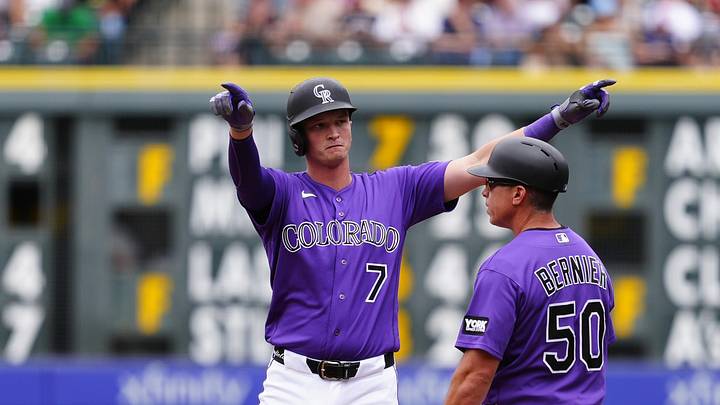  Colorado Rockies first baseman TJ Rumfield (7) celebrates his RBI single with first base coach Doug Bernier (50).
