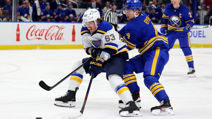 Nov 14, 2024; Buffalo, New York, USA;  St. Louis Blues left wing Jake Neighbours (63) skates with the puck as Buffalo Sabres defenseman Bowen Byram (4) defends during the first period at KeyBank Center. Mandatory Credit: Timothy T. Ludwig-Imagn Images