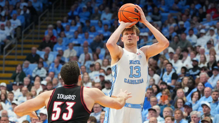 Feb 23, 2026; Chapel Hill, North Carolina, USA; North Carolina Tar Heels center Henri Veesaar (13) shoots a three point shot as Louisville Cardinals forward Vangelis Zougris (53) defends in the second half at Dean E. Smith Center. Mandatory Credit: Bob Donnan-Imagn Images