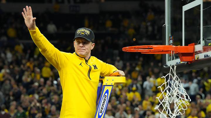 Apr 6, 2026; Indianapolis, IN, USA; Michigan Wolverines head coach Dusty May waves to the crowd as he cuts down the net after defeating the Connecticut Huskies in the national championship of the Final Four of the men's 2026 NCAA Tournament at Lucas Oil Stadium. Mandatory Credit: Robert Deutsch-Imagn Images
