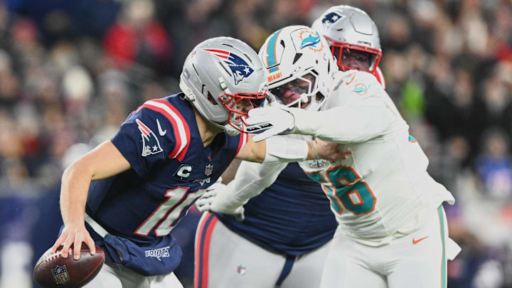 Jan 4, 2026; Foxborough, Massachusetts, USA; New England Patriots quarterback Drake Maye (10) scrambles against Miami Dolphins linebacker Quinton Bell (56) during the first quarter at Gillette Stadium. Mandatory Credit: Brian Fluharty-Imagn Images