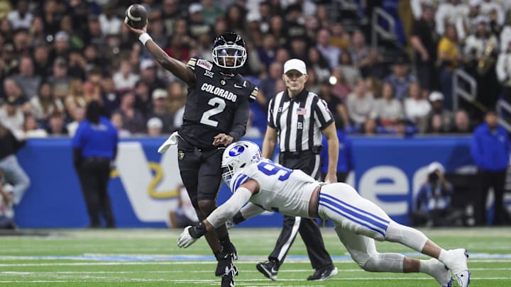 Dec 28, 2024; San Antonio, TX, USA; Colorado Buffaloes quarterback Shedeur Sanders (2) attempts a pass as Brigham Young Cougars defensive end Tyler Batty (92) attempts to make a tackle during the third quarter at Alamodome.  