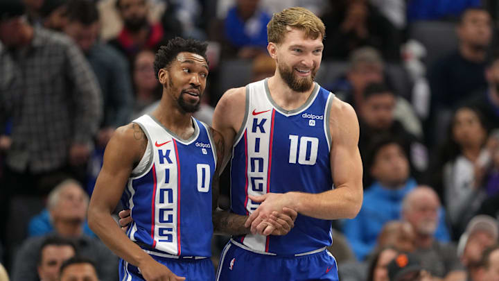 Dec 4, 2023; Sacramento, California, USA; Sacramento Kings guard Malik Monk (0) talks with forward Domantas Sabonis (10) during the second quarter against the New Orleans Pelicans at Golden 1 Center. Mandatory Credit: Darren Yamashita-USA TODAY Sports