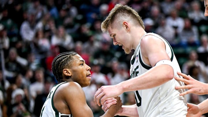 Michigan State's Jaxon Kohler, center, helps Jeremy Fears Jr., left, up off the floor after Fears' scored and drew a Nebraska foul during the second half on Saturday, Dec. 7, 2024, at the Breslin Center in East Lansing. At right is MSU's Szymon Zapala.