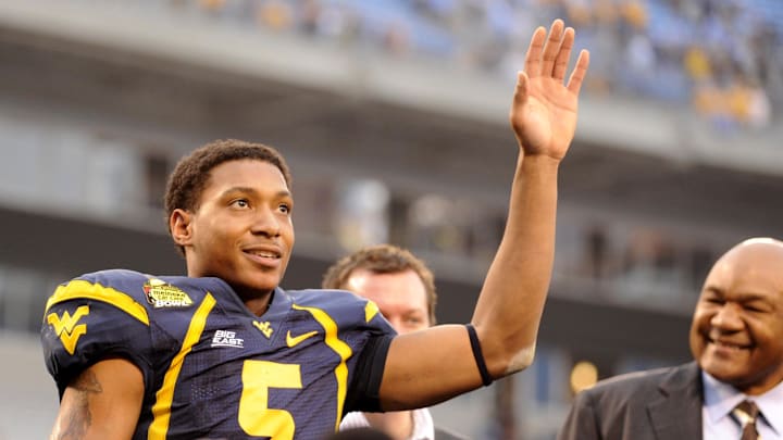 Dec. 27, 2008; Charlotte, NC, USA; West Virginia Mountaneers  quarterback Pat White (5) reacts after the Mountaineers 31-30 victory against the North Carolina Tar Heels with Meineke spokesman George Foreman to the right at Bank of America Stadium. Mandatory Credit: Bob Donnan-Imagn Images