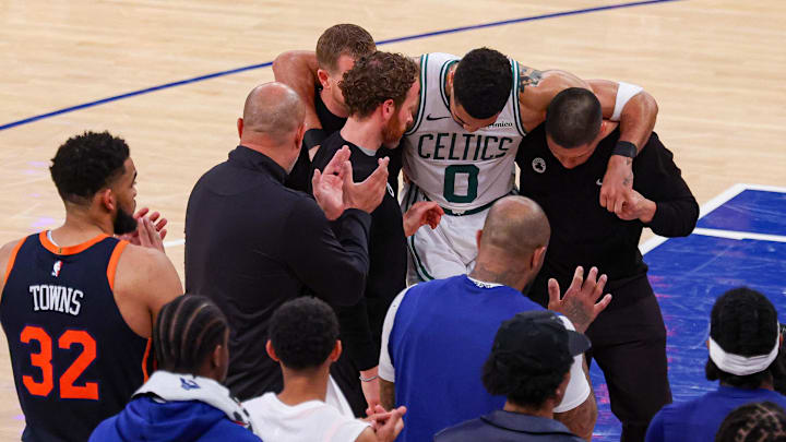 May 12, 2025; New York, New York, USA; Boston Celtics forward Jayson Tatum (0) is helped off the court by after an injury in the second half during game four of the second round for the 2025 NBA Playoffs against the New York Knicks at Madison Square Garden. Tatum would leave the game with an injury after this play. Mandatory Credit: Vincent Carchietta-Imagn Images