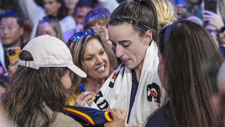 May 10, 2025; Atlanta, GA, USA; Indiana Fever guard Caitlin Clark (22) signs autographs on her way off the court after the Fever defeated the Atlanta Dream at Gateway Center Arena @ College Park. Mandatory Credit: Dale Zanine-Imagn Images