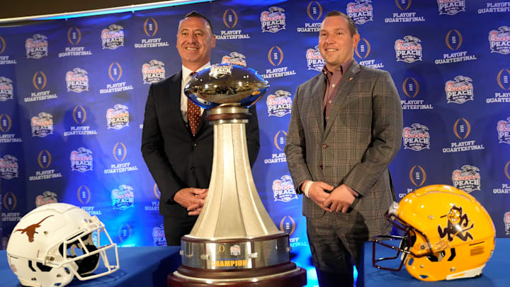 Texas head coach Steve Sarkisian and Arizona State head coach Kenny Dillingham pose for photos before facing off in the Chick-fil-A Peach Bowl.