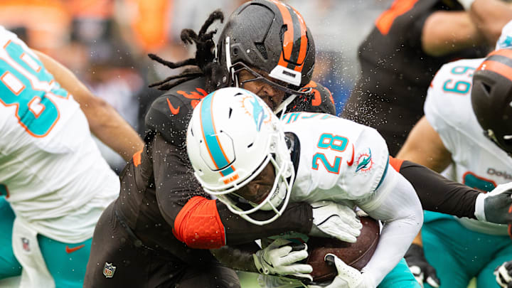 Cleveland Browns linebacker Devin Bush (30) tackles Miami Dolphins running back De'Von Achane (28) during the first quarter at Huntington Bank Field. 