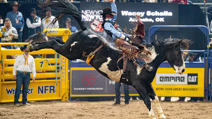 Wacey Schalla and the horse Trooper winning a fourth place check in round three of the bareback riding at the 2025 NFR