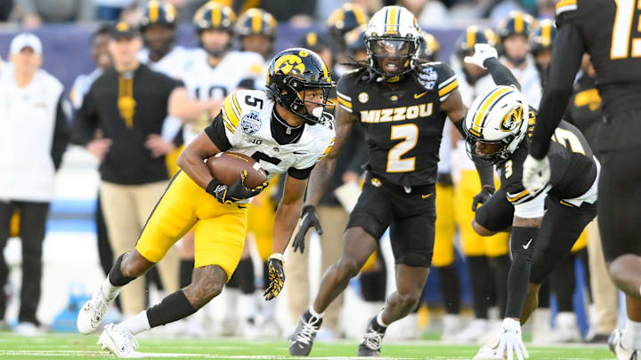 Dec 30, 2024; Nashville, TN, USA;  Iowa Hawkeyes wide receiver Jacob Gill (5) runs through the tackle of Missouri Tigers cornerback Toriano Pride Jr. (2) during the second half at Nissan Stadium. Mandatory Credit: Steve Roberts-Imagn Images