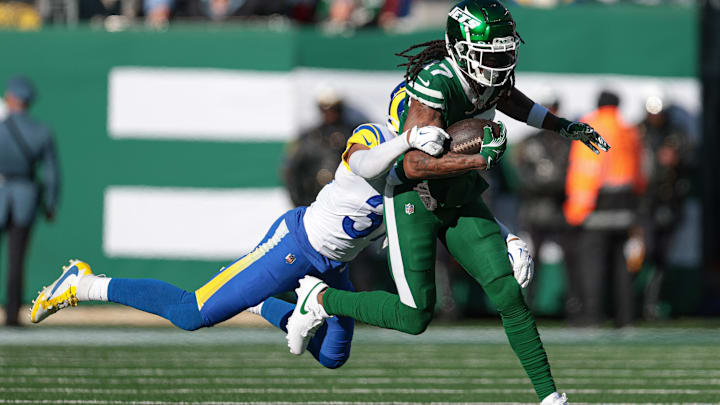 Dec 22, 2024; East Rutherford, New Jersey, USA; New York Jets wide receiver Davante Adams (17) fights for yards  as Los Angeles Rams safety Quentin Lake (37) tackles during the first half at MetLife Stadium. Mandatory Credit: Vincent Carchietta-Imagn Images